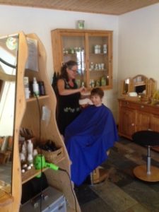Ich, Susanne Lins beim Schneiden der Haare einer Kundin, im Naturfriseur Grüne Schere in Jean