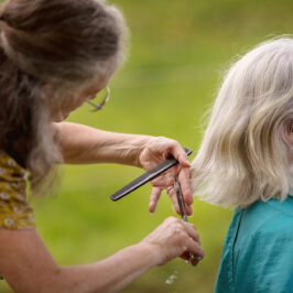 Susanne schneidet einer Kundin mitten in der Natur energetisch die Haare