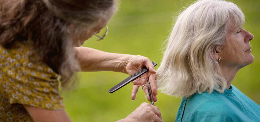 Susanne schneidet einer Kundin mitten in der Natur energetisch die Haare